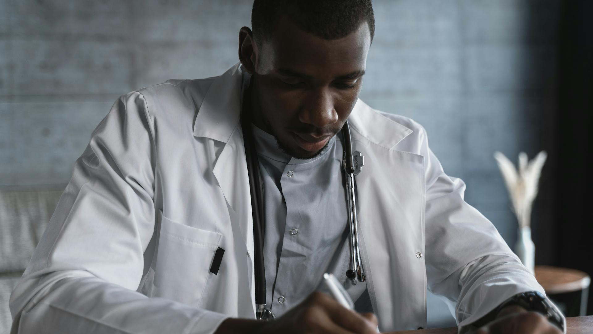 Doctor writing medical notes with stethoscope